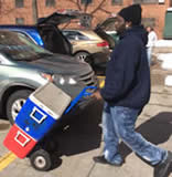 A man moving two coolers with a hand truck