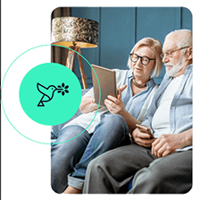 Blooming Health logo and a couple sitting on a couch reading a brochure