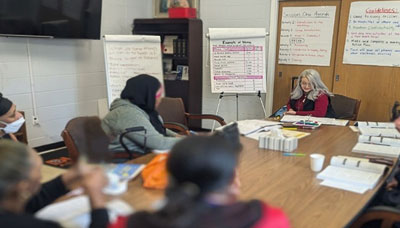 A group of people sitting at a conference table with notes and charts.