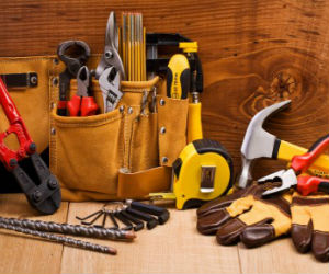 Home repair tools, including a tape measure, hammer, tool belt, gloves, wrenches and more