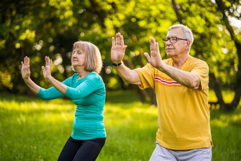 Two seniors practicing tai chi outdoors
