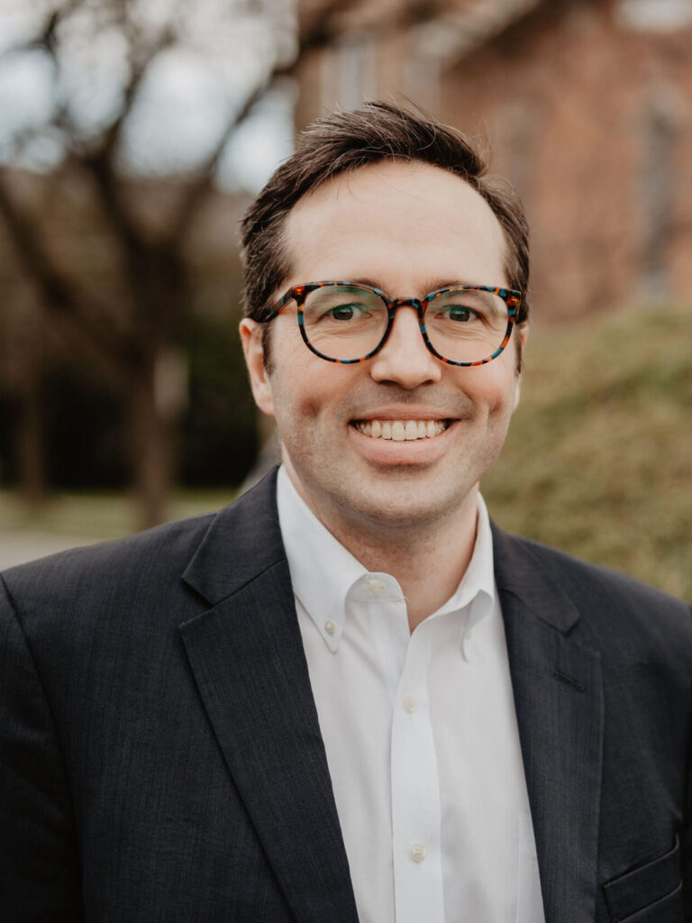 Male with dark blazer and glasses, white shirt
