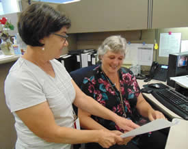 Two women looking at a document while in an office